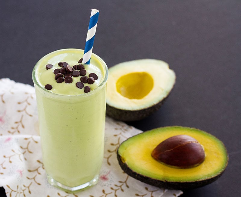 Avocado-Milkshake-1.jpg Glass of California Avocado milkshake topped with chocolate chips next to a cut avocado