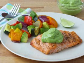 Plate of baked salmon with avocado salad and sauce